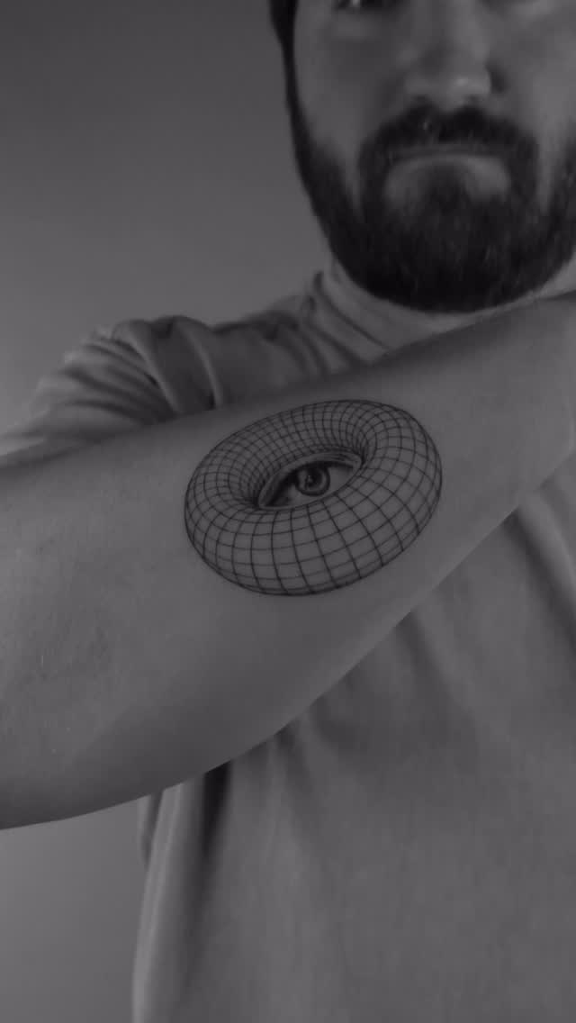 Wireframe torus with a realistic eye on a forearm